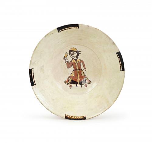 A NISHAPUR SLIP-PAINTED POTTERY BOWL DEPICTING A SEATED FIGURE, PERSIA, 10TH CENTURY