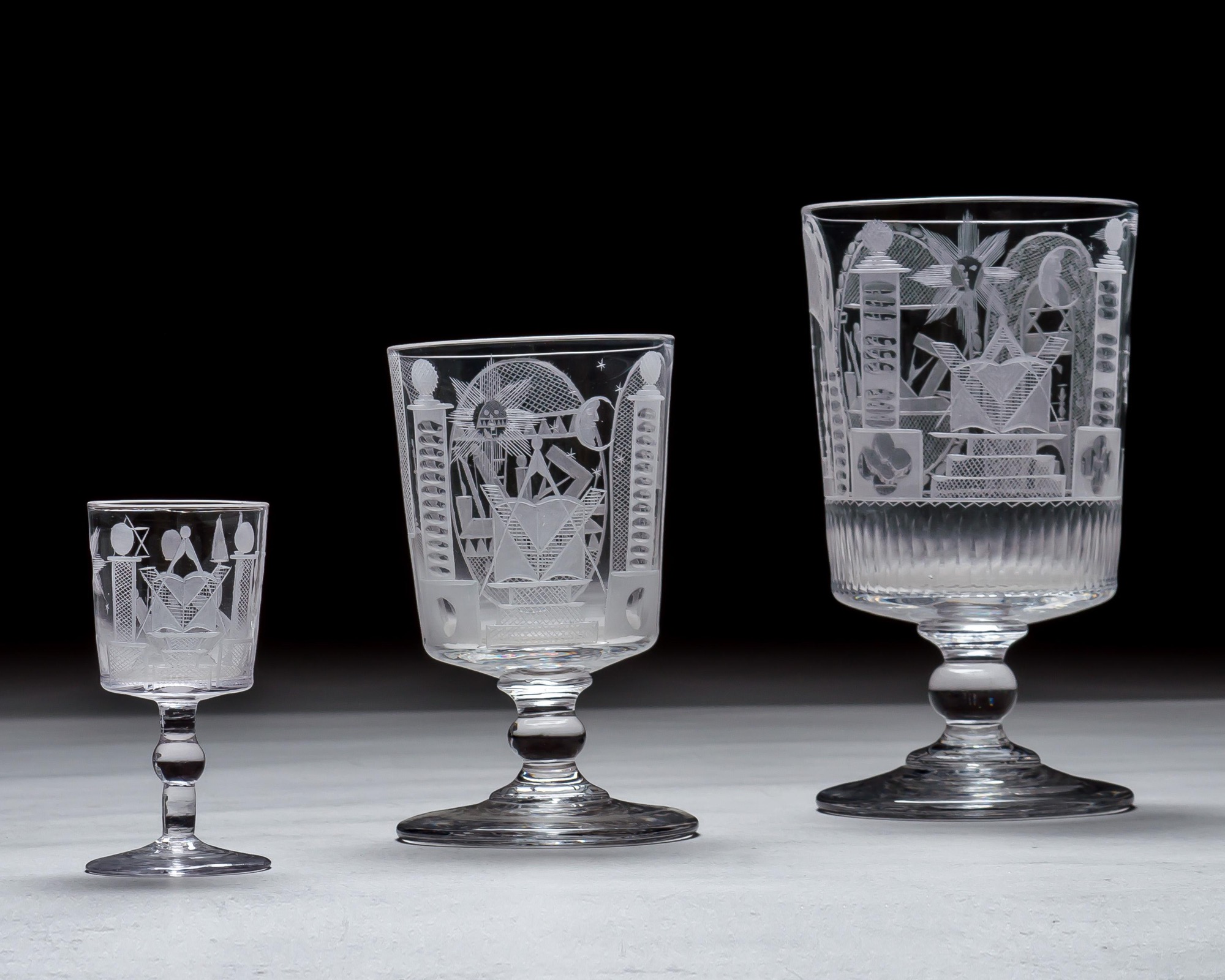 AN ENGRAVED GLASS SERVICE OF MASONIC INTEREST ALONG WITH A COLLECTION OF CORRESPONDING MASONIC REGALIA