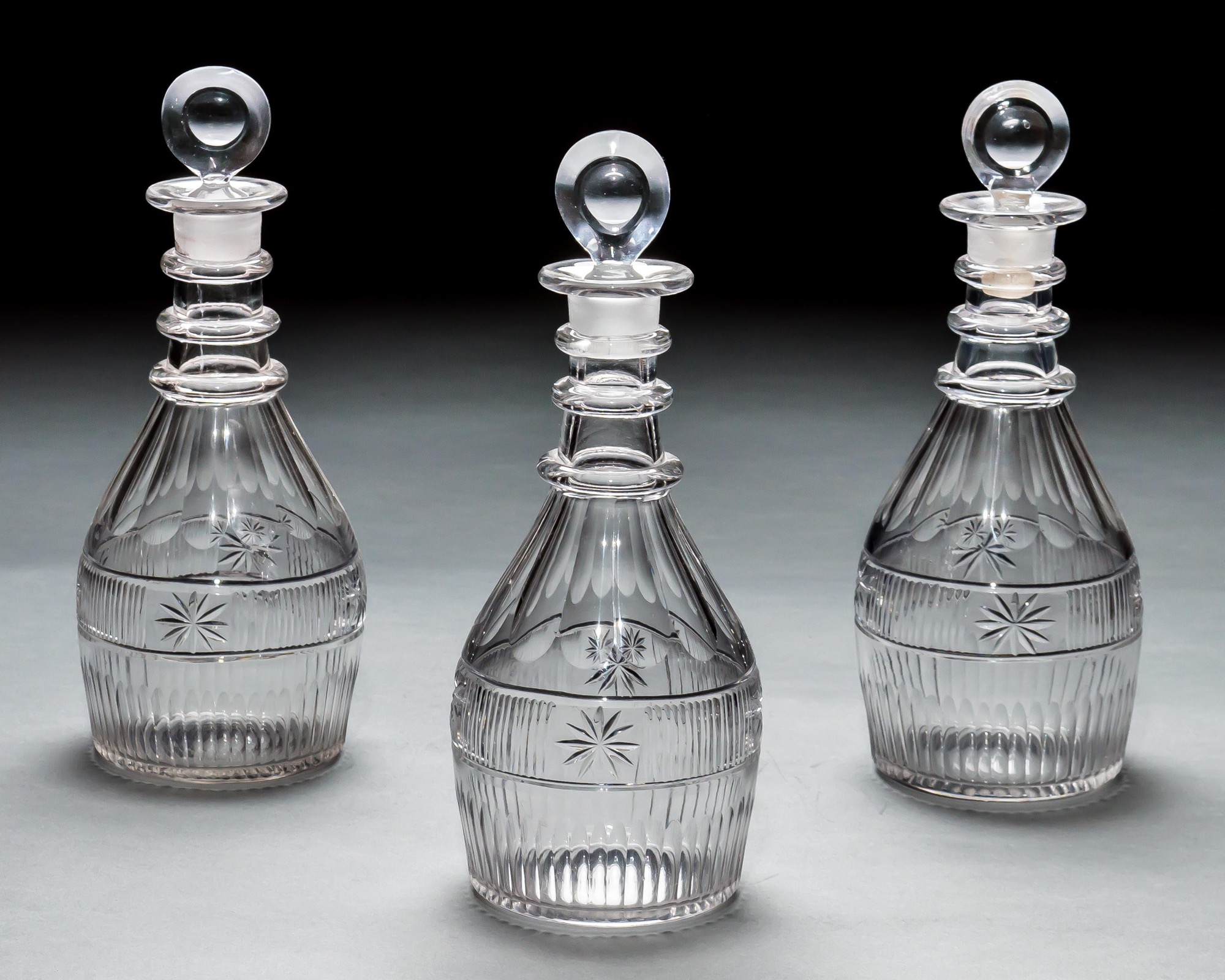 A SET OF THREE SLICE & FLUTE DECANTERS