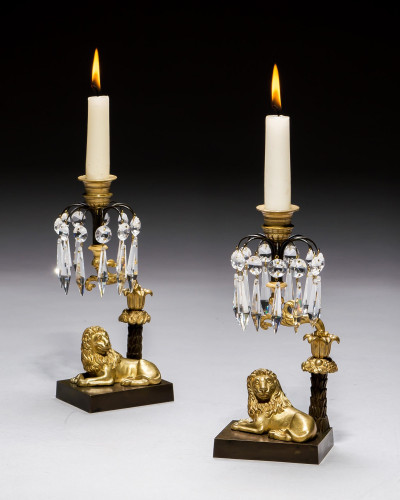 A MAJESTIC PAIR OF GILT & BRONZE LION CANDLESTICKS
