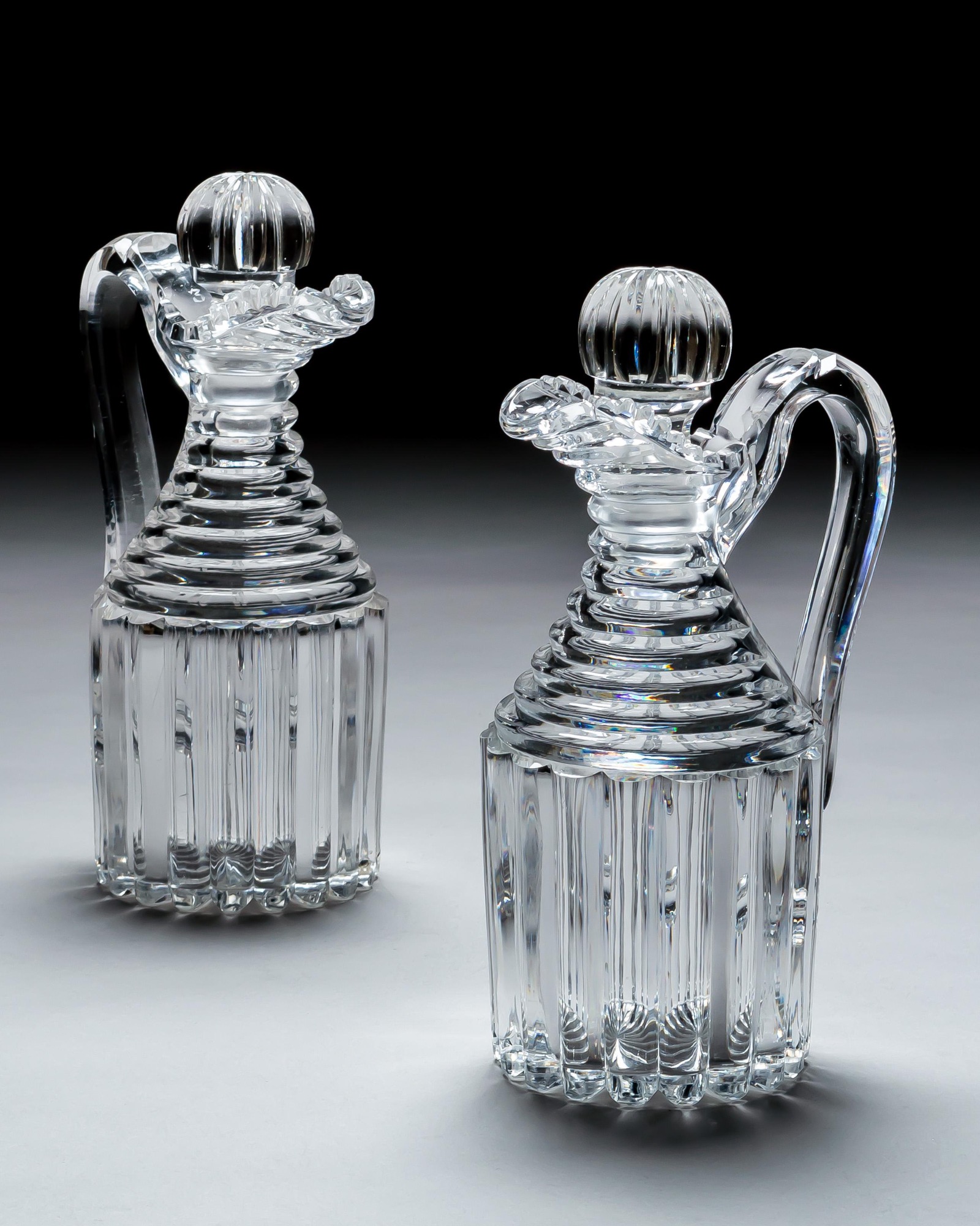 A PAIR OF PILLAR CUT REGENCY CLARET JUGS