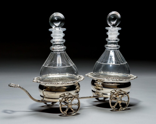 A SILVER PLATED WAGON DECANTER STAND