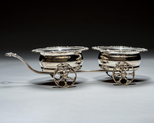 A SILVER PLATED WAGON DECANTER STAND