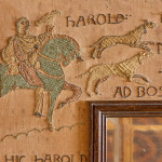 An unusual Arts & Crafts oak and embroidered mirror