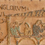 An unusual Arts & Crafts oak and embroidered mirror