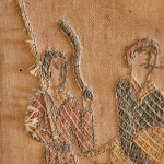 An unusual Arts & Crafts oak and embroidered mirror