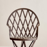 A riveted patinated metal garden chair