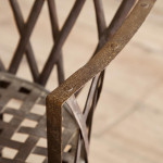 A riveted patinated metal garden chair
