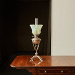 A model 394 silver-plated Arts & Crafts oil lamp on stand by W.A.S. Benson (1858 - 1924) with original vaseline glass shade by James Powell & Sons