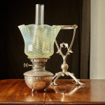 A model 394 silver-plated Arts & Crafts oil lamp on stand by W.A.S. Benson (1858 - 1924) with original vaseline glass shade by James Powell & Sons