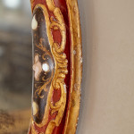 An 18th century carved parcel-gilt and red lacquered Venetian mirror