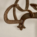 A collection of seven patinated wrought iron bridle hooks originally from Middleton Park, Oxfordshire