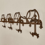 A collection of seven patinated wrought iron bridle hooks originally from Middleton Park, Oxfordshire