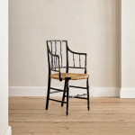 An ebonised and painted elbow chair