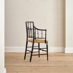 An ebonised and painted elbow chair