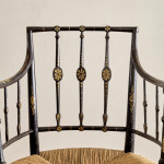 An ebonised and painted elbow chair