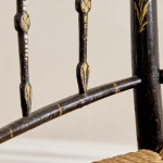 An ebonised and painted elbow chair