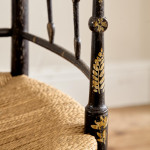 An ebonised and painted elbow chair