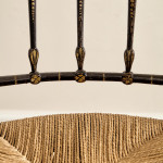 An ebonised and painted elbow chair