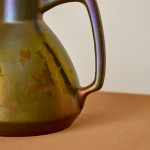 An iridescent glazed ceramic jug by Montières Pottery