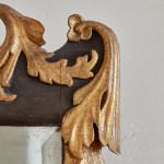 A rectangular mirror with an ebonised and parcel gilt carved frame
