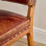 A Reformed Gothic oak upholstered side chair covered in the original red leather