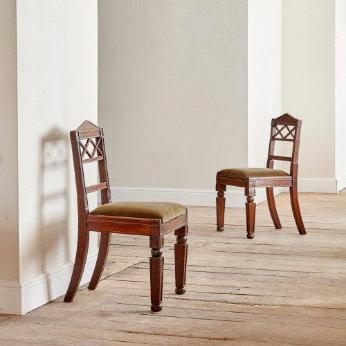 A pair of Regency oak hall chairs in the manner of George Bullock (1777-1818)