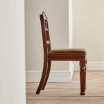 A pair of Regency oak hall chairs in the manner of George Bullock (1777-1818)