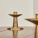 A pair of hexagonal brass candlesticks with geometric decoration