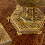 A pair of hexagonal brass candlesticks with geometric decoration