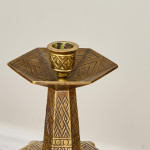 A pair of hexagonal brass candlesticks with geometric decoration