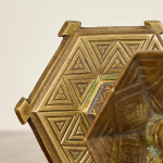 A pair of hexagonal brass candlesticks with geometric decoration