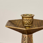 A pair of hexagonal brass candlesticks with geometric decoration