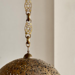 A large brass shadow ball pendant