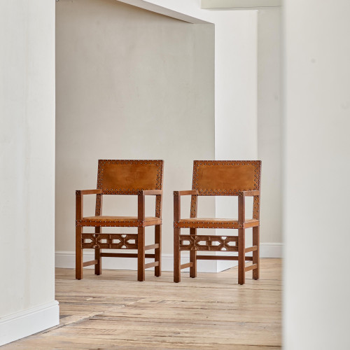 A pair of Arts and Crafts oak and leather armchairs