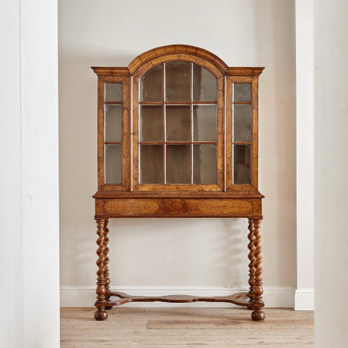 An unusual William & Mary style burr oak and seaweed marquetry glazed cabinet on stand