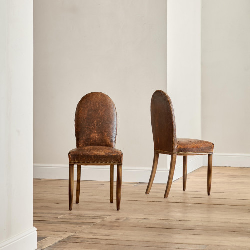 A pair of Art Deco beech and leather upholstered side chairs in the manner of Poul Follot (1877 - 1941)