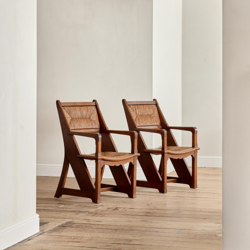 A pair of Arts & Crafts oak and rush elbow chairs