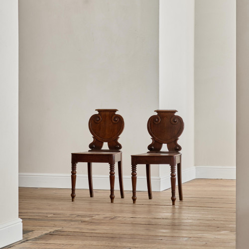 A pair of George IV oak hall chairs