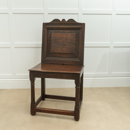 A Charles II oak enclosed backstool, English, circa 1640