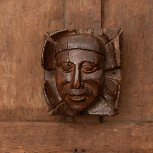An arresting oak boss carved with the head of a man, Devon, circa 1450-1500