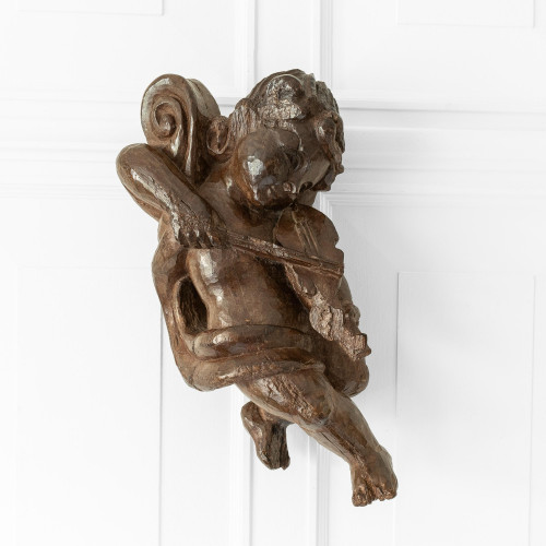 A large Elizabeth I walnut putto or cherub, circa 1590
