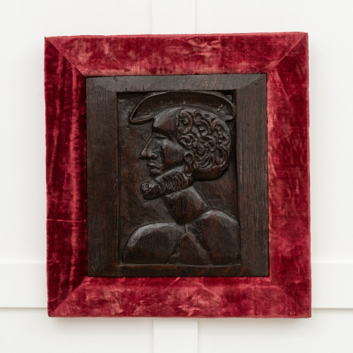 A Henry VIII carved oak portrait panel, circa 1520