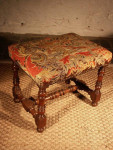 A good, early-18th century, walnut stool with a needlework seat