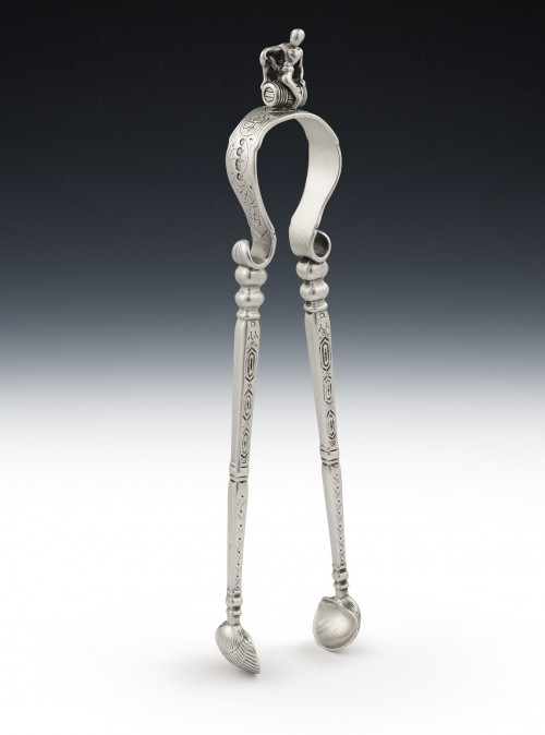 An extremely rare pair of Sugar Tongs modelled as a pair of Fire Irons, with a boy on a barrel above.  Made in London in 1853 by Francis Higgins.